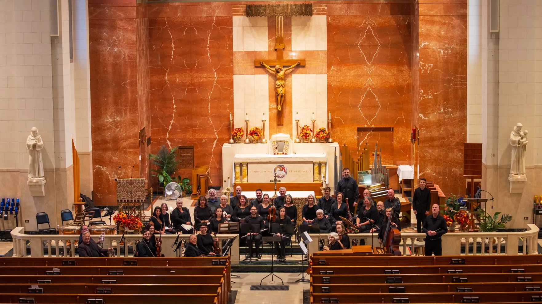 Esky Baroque musicians gathered with their instruments in front of the church altar